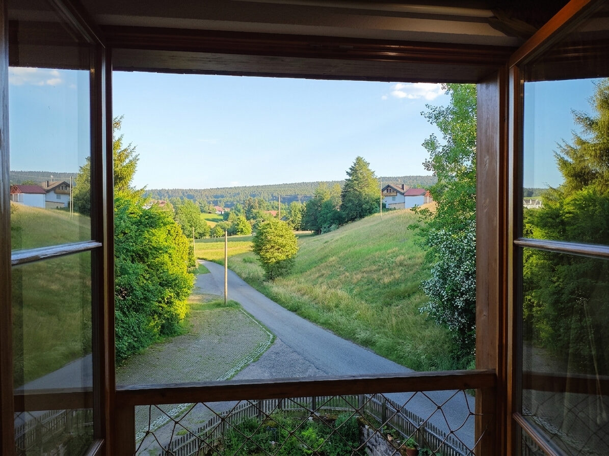 Blick aus dem Fenster auf die ruhige Straße und die Hügel